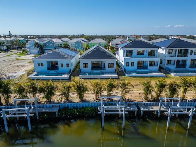 back of property featuring a water view, boat lift, and a residential view