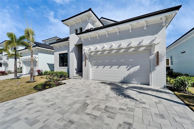 view of front of house with a pergola, decorative driveway, and stucco siding