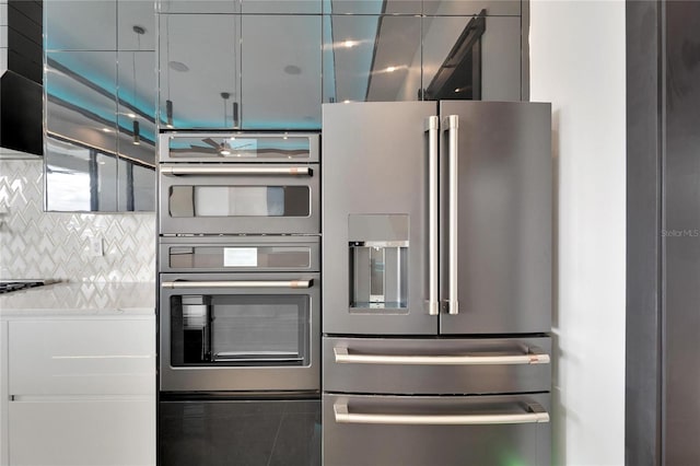 kitchen featuring stainless steel appliances, backsplash, and light countertops