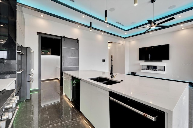 kitchen with dishwasher, a barn door, modern cabinets, and a sink