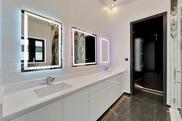 full bathroom with marble finish floor, a sink, and double vanity