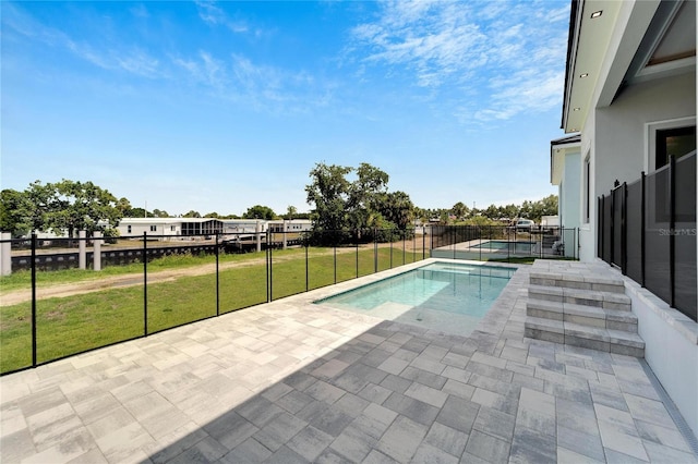 view of swimming pool with a patio, a lawn, fence, and a fenced in pool