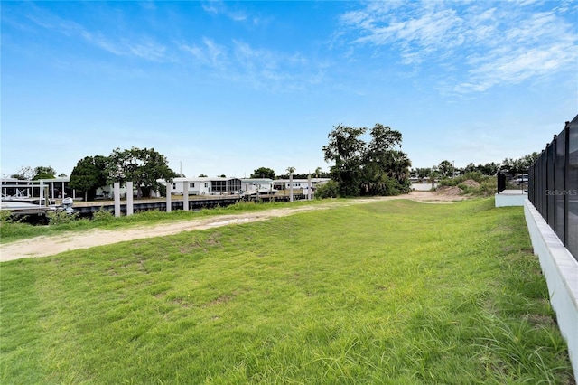 view of yard with driveway and fence