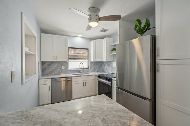 kitchen with white cabinets, stainless steel appliances, backsplash, ceiling fan, and sink