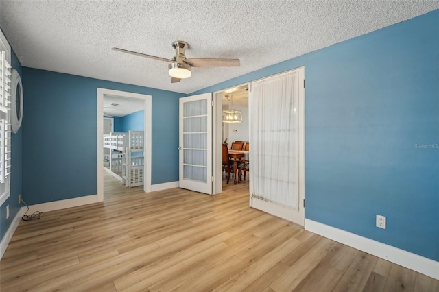 interior space featuring ceiling fan, light hardwood / wood-style floors, and a textured ceiling