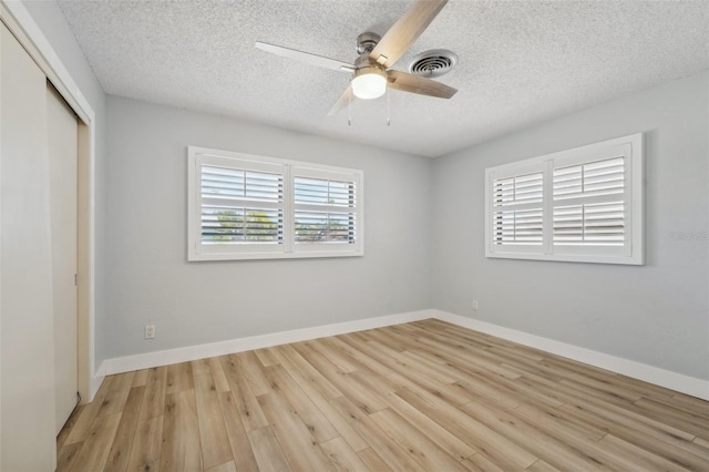 unfurnished bedroom with a closet, ceiling fan, light hardwood / wood-style flooring, and a textured ceiling