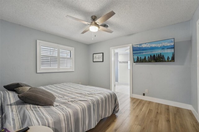 bedroom featuring a textured ceiling, wood-type flooring, and ceiling fan