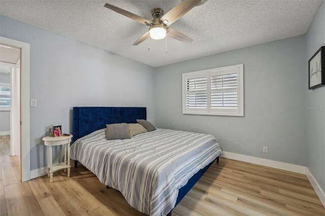 bedroom featuring light hardwood / wood-style floors, a textured ceiling, and ceiling fan