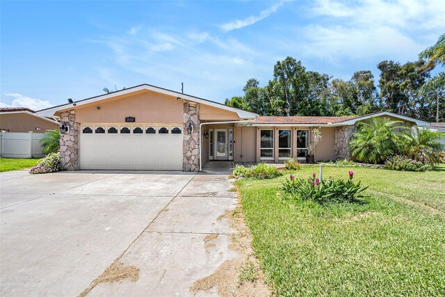 ranch-style house featuring a front yard and a garage