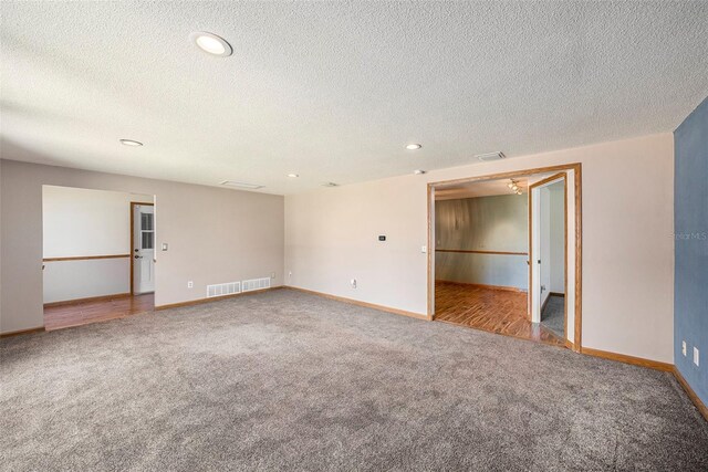 empty room with a textured ceiling and light colored carpet