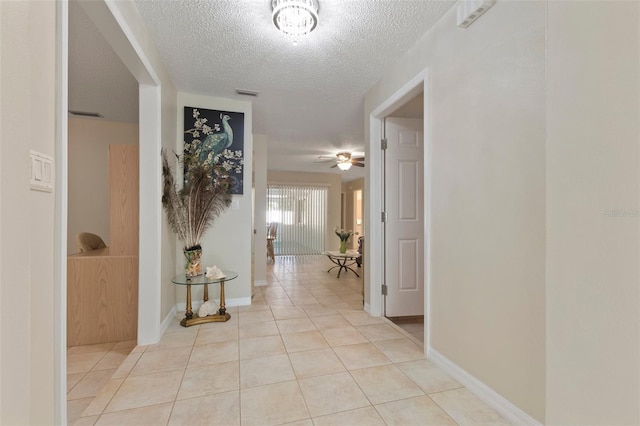 hall with light tile patterned floors and a textured ceiling