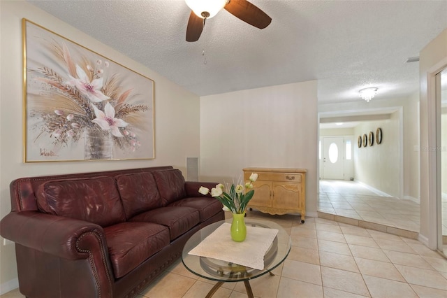 living room with light tile patterned floors, a textured ceiling, and ceiling fan