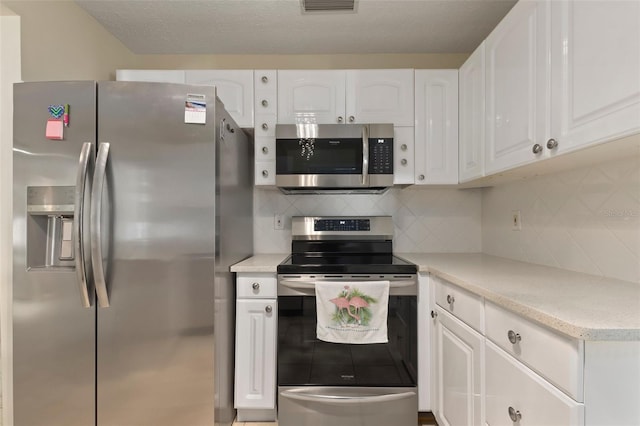 kitchen with decorative backsplash, white cabinetry, and stainless steel appliances