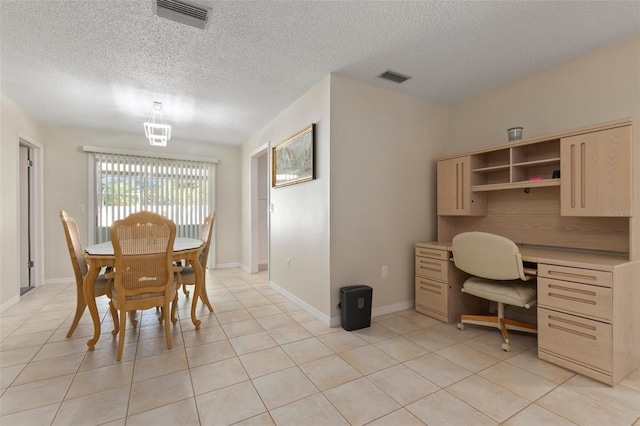 dining space featuring light tile patterned floors and a textured ceiling