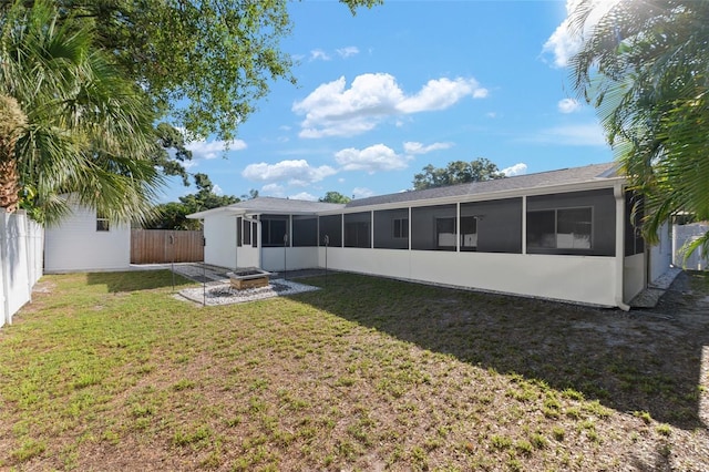 back of property with a sunroom and a yard