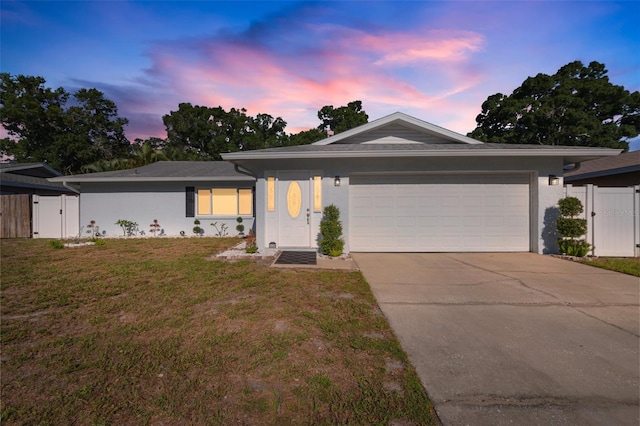 ranch-style house featuring a lawn and a garage