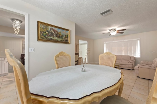 dining room with ceiling fan, light tile patterned floors, and a textured ceiling