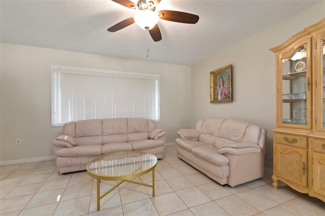 living room featuring ceiling fan, light tile patterned flooring, and a textured ceiling