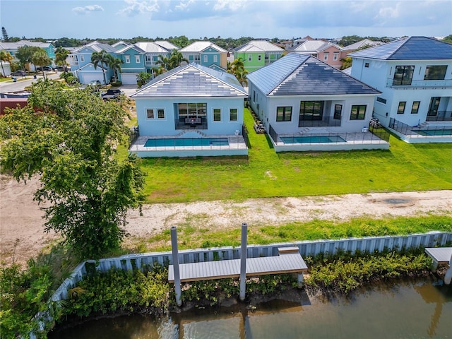 rear view of property with a yard, a water view, and a patio area