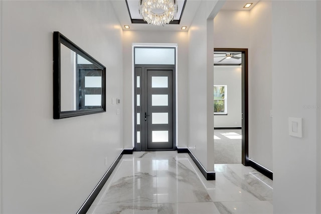 entryway with ceiling fan with notable chandelier