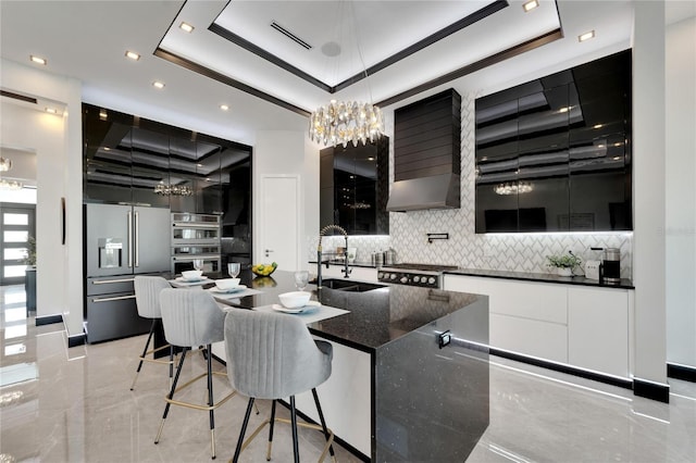 kitchen featuring sink, stainless steel appliances, a tray ceiling, and tasteful backsplash