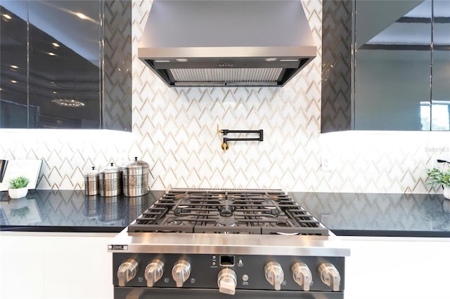 kitchen with backsplash, stainless steel stove, and wall chimney exhaust hood