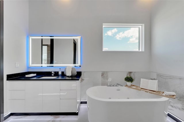 bathroom featuring tile patterned flooring, vanity, a bathtub, and tile walls