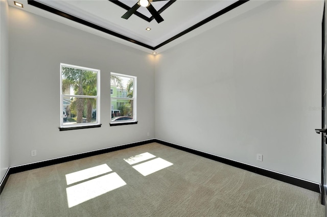 carpeted empty room featuring a tray ceiling and ceiling fan