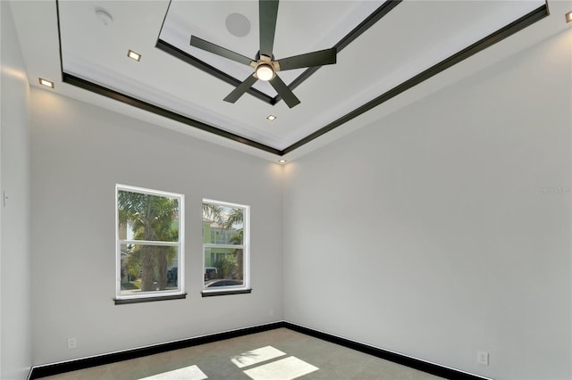 empty room with a tray ceiling, ceiling fan, and crown molding