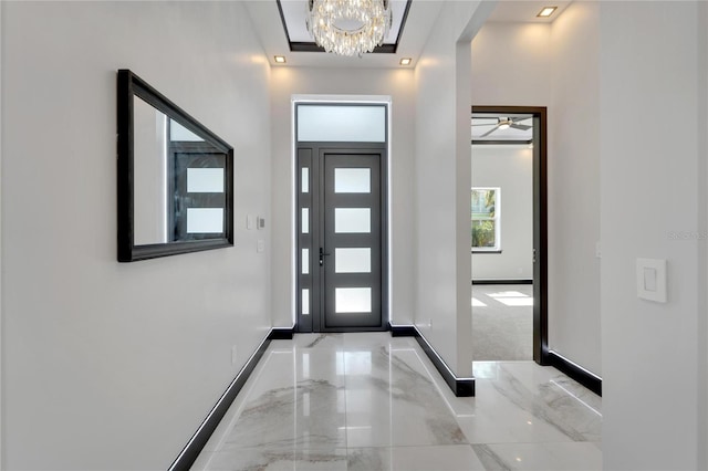 6542 Simone Shores Cir, Apollo Beach, FL 33572 - foyer entrance featuring baseboards, light marble finish floors, and a chandelier