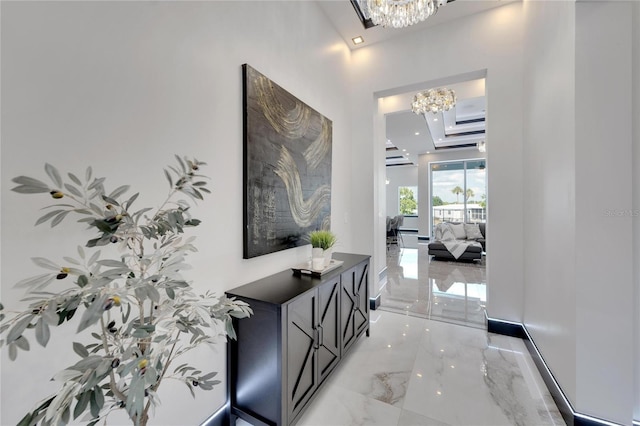 6542 Simone Shores Cir, Apollo Beach, FL 33572 - hallway with a chandelier, light marble finish flooring, and a raised ceiling