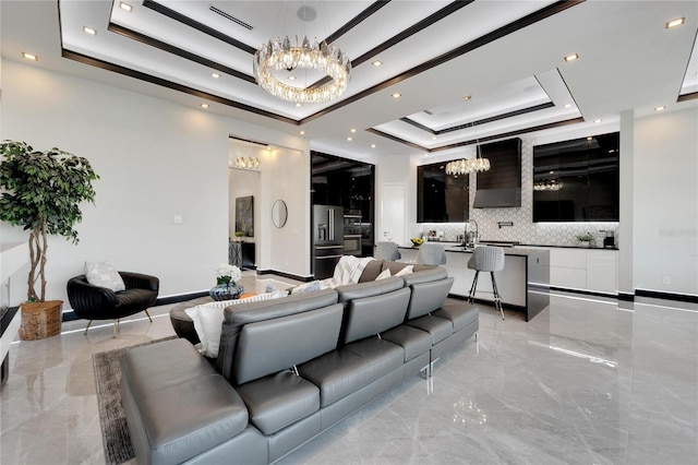 6542 Simone Shores Cir, Apollo Beach, FL 33572 - living room featuring a tray ceiling, a chandelier, light marble finish floors, and recessed lighting