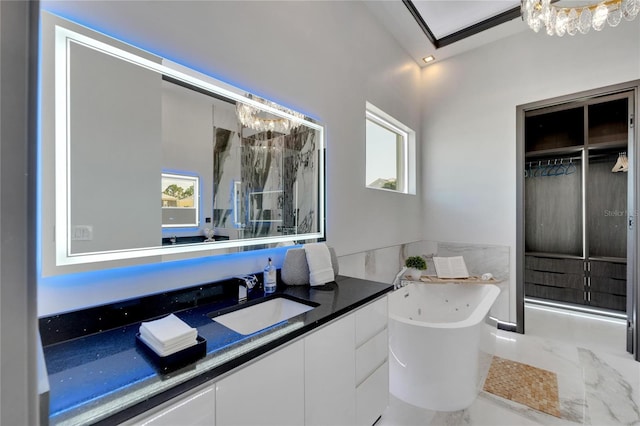 6542 Simone Shores Cir, Apollo Beach, FL 33572 - full bath with a chandelier, a freestanding tub, vanity, marble finish floors, and a shower with door