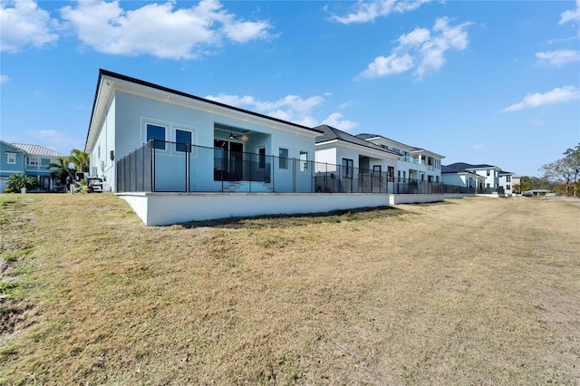 6542 Simone Shores Cir, Apollo Beach, FL 33572 - rear view of house with a ceiling fan, a lawn, a residential view, and stucco siding