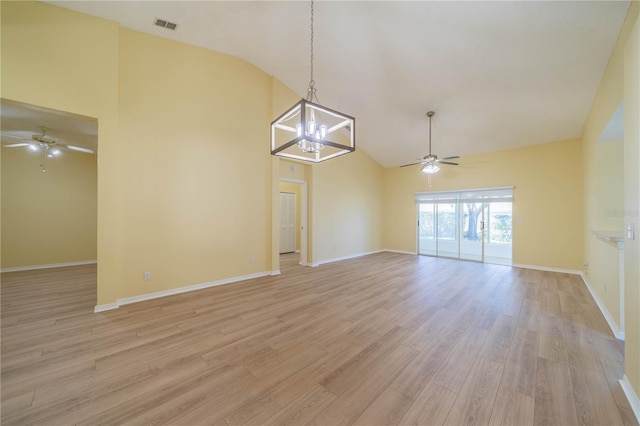 unfurnished room featuring light wood-type flooring, high vaulted ceiling, visible vents, and ceiling fan with notable chandelier