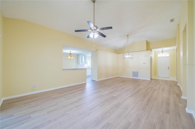 interior space featuring visible vents, baseboards, lofted ceiling, light wood-type flooring, and ceiling fan with notable chandelier