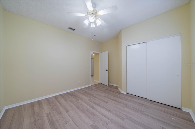 unfurnished bedroom featuring baseboards, visible vents, ceiling fan, light wood-type flooring, and a closet