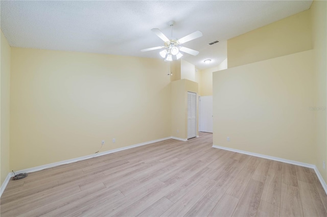 spare room featuring baseboards, ceiling fan, visible vents, and light wood-style floors