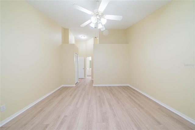 unfurnished room with a ceiling fan, baseboards, and light wood finished floors