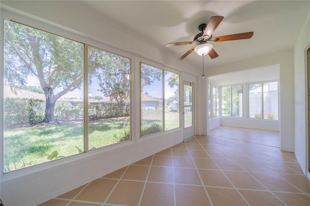 unfurnished sunroom with a ceiling fan