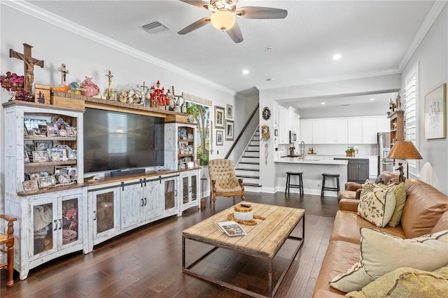 living room featuring dark hardwood / wood-style floors, ceiling fan, and crown molding