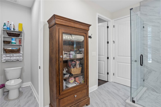 bathroom with toilet and a shower with door