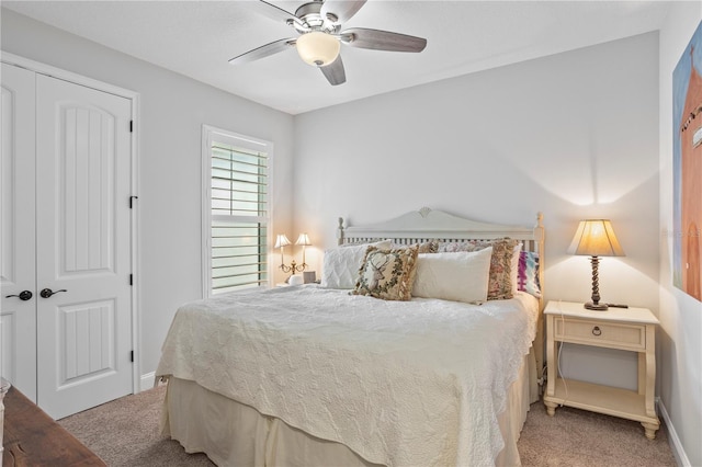 carpeted bedroom with ceiling fan and a closet