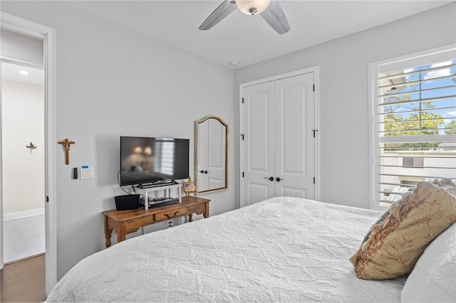 bedroom featuring ceiling fan, a closet, and hardwood / wood-style flooring