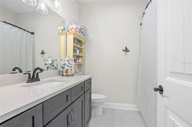 bathroom with tile patterned flooring, vanity, and toilet