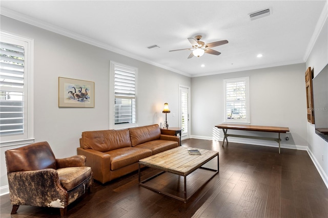 living area with baseboards, visible vents, dark wood finished floors, and ornamental molding