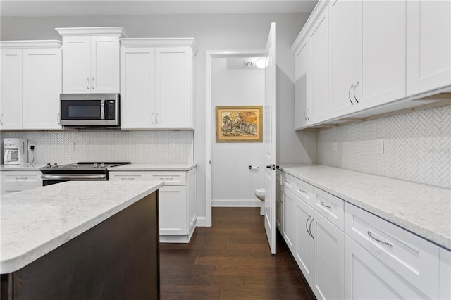 kitchen featuring baseboards, stainless steel appliances, dark wood-type flooring, and white cabinets