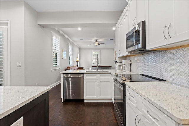 kitchen featuring decorative backsplash, appliances with stainless steel finishes, dark wood-type flooring, light stone countertops, and white cabinetry