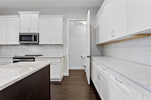 4606 W Fig St Unit 4, Tampa, FL 33609 - kitchen with stainless steel appliances, tasteful backsplash, white cabinetry, and light stone counters