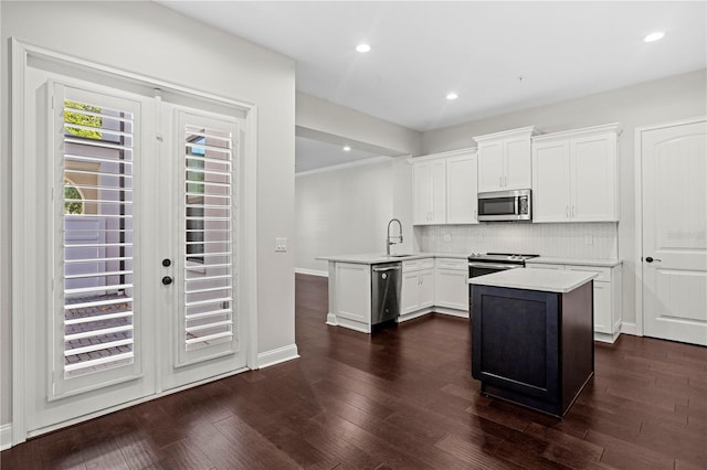 4606 W Fig St Unit 4, Tampa, FL 33609 - kitchen with appliances with stainless steel finishes, a sink, backsplash, white cabinetry, and recessed lighting